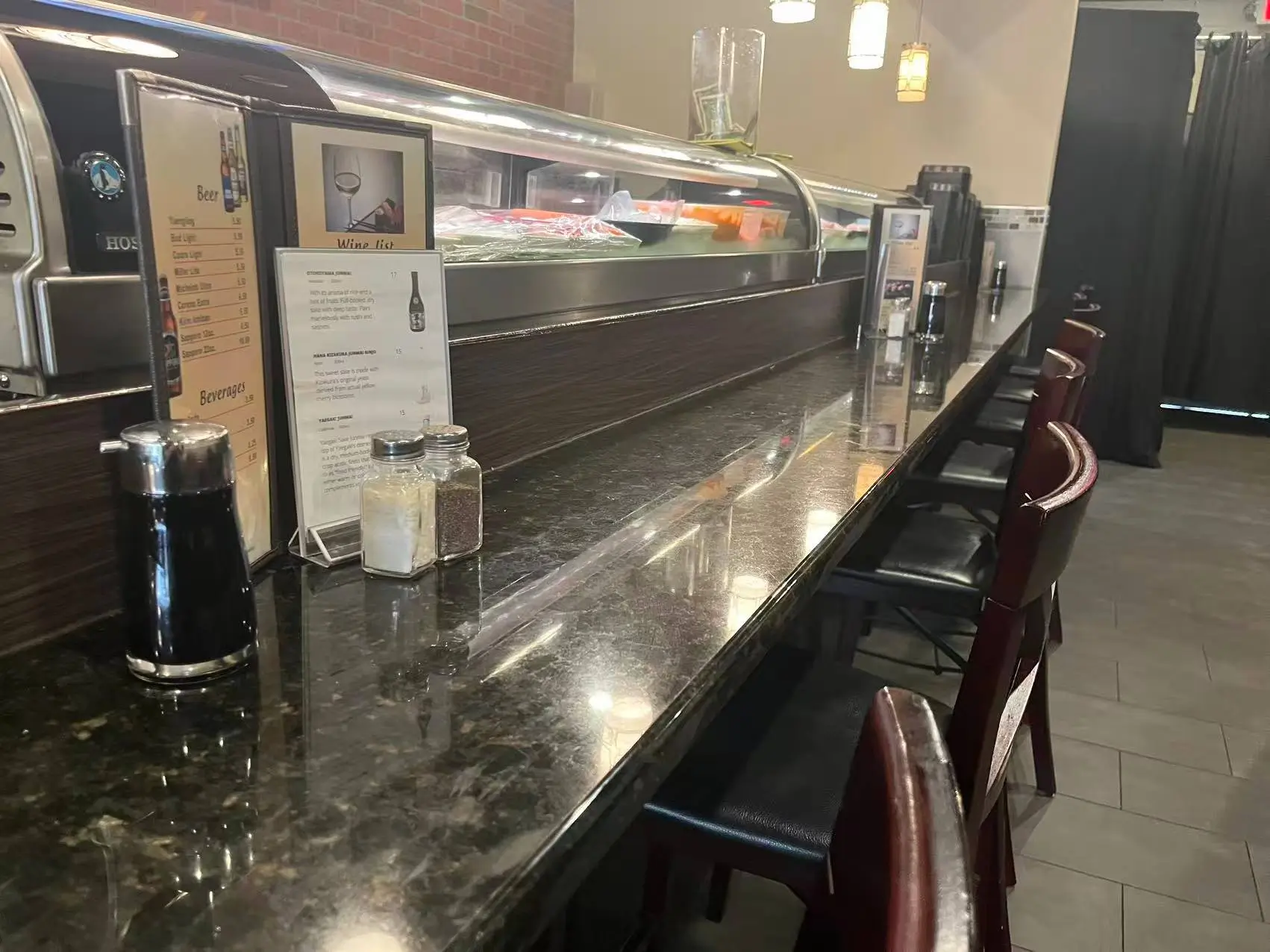 Marble-topped sushi bar counter with condiments and menus at Tokyo Sushi, a Japanese Restaurant in Ocala