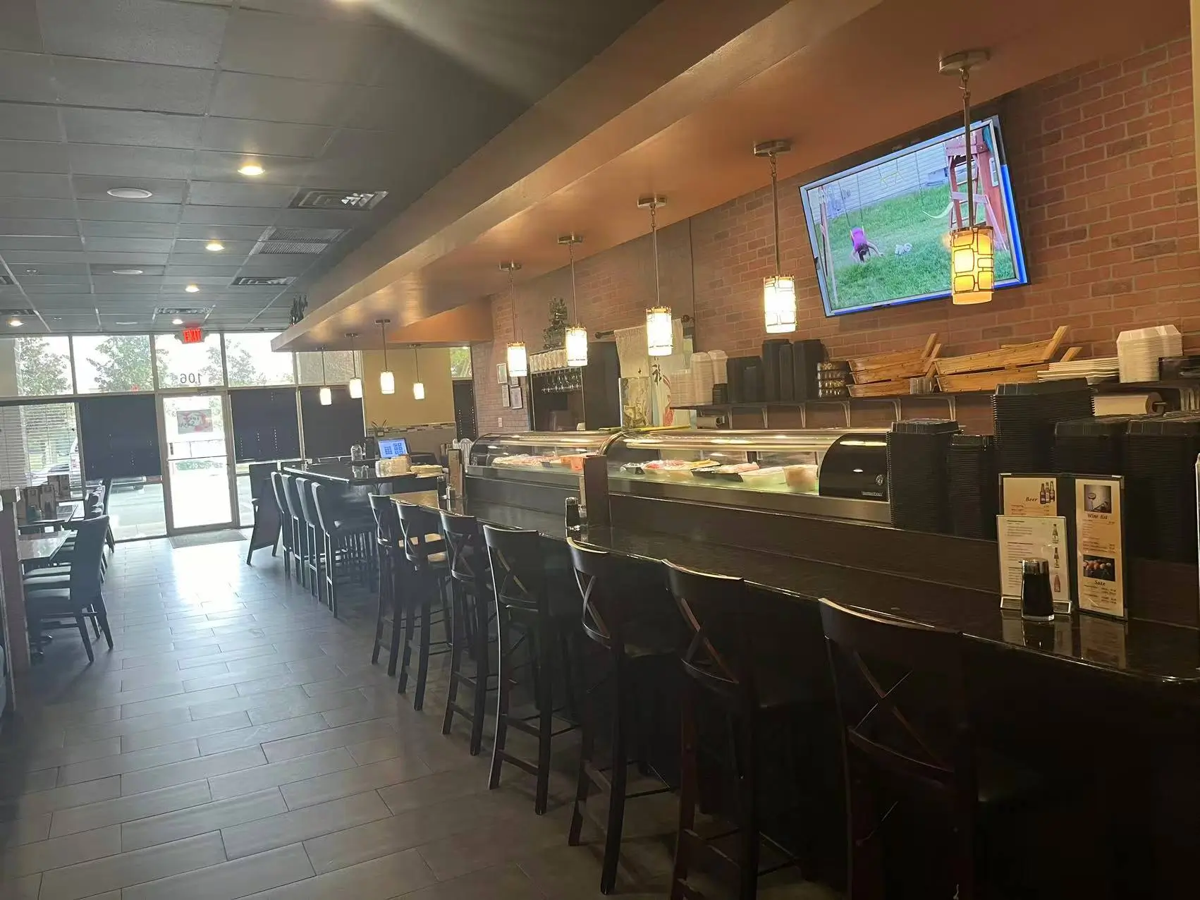 Sushi bar with counter seating, display case and hanging lights at Tokyo Sushi, a Japanese Restaurant in Ocala