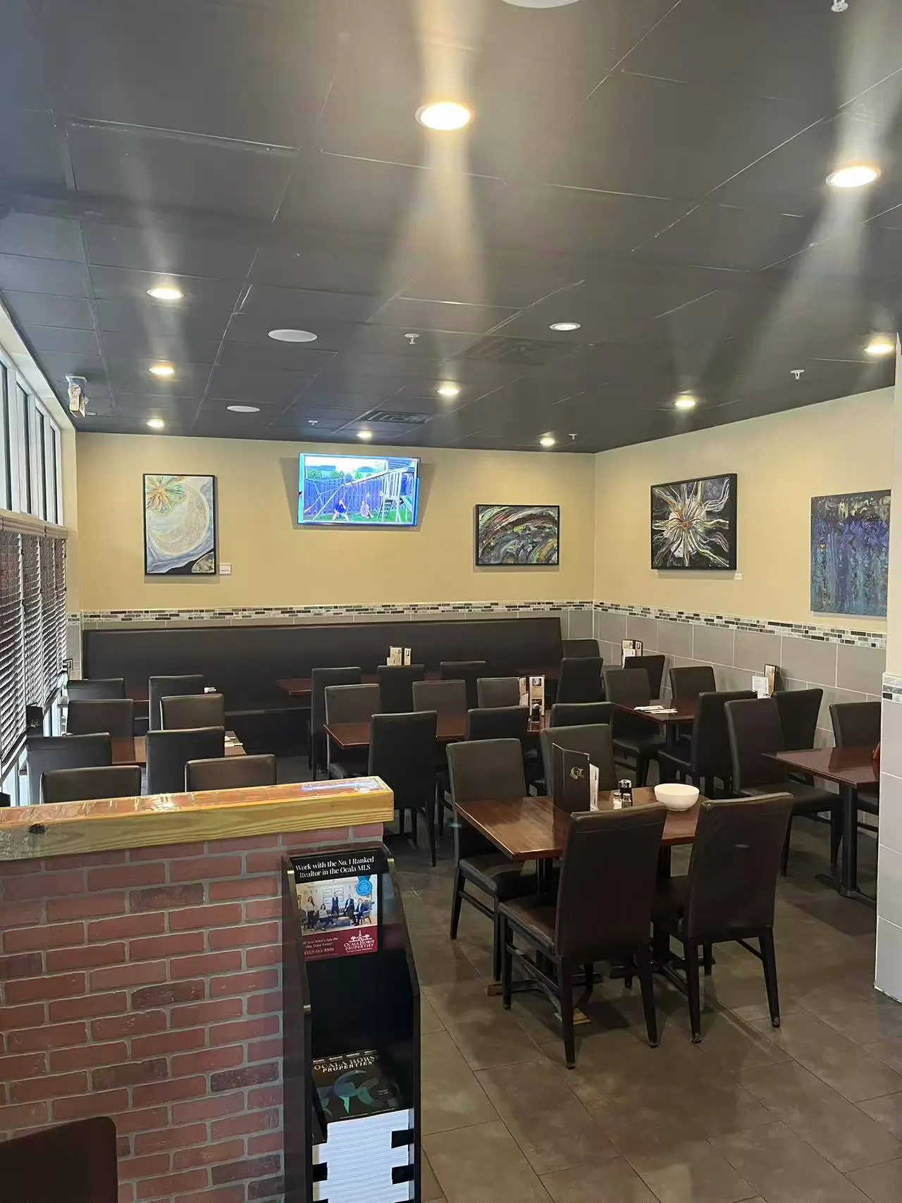 Seating area with tables, booths, artworks and a TV at Tokyo Sushi, a Japanese Restaurant in Ocala